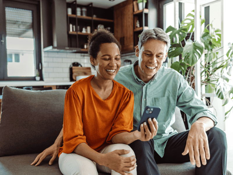 couple on couch looking at phone